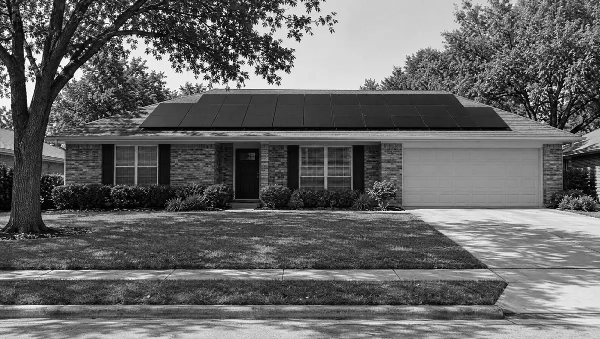 A brick ranch house with solar panels on the roof.